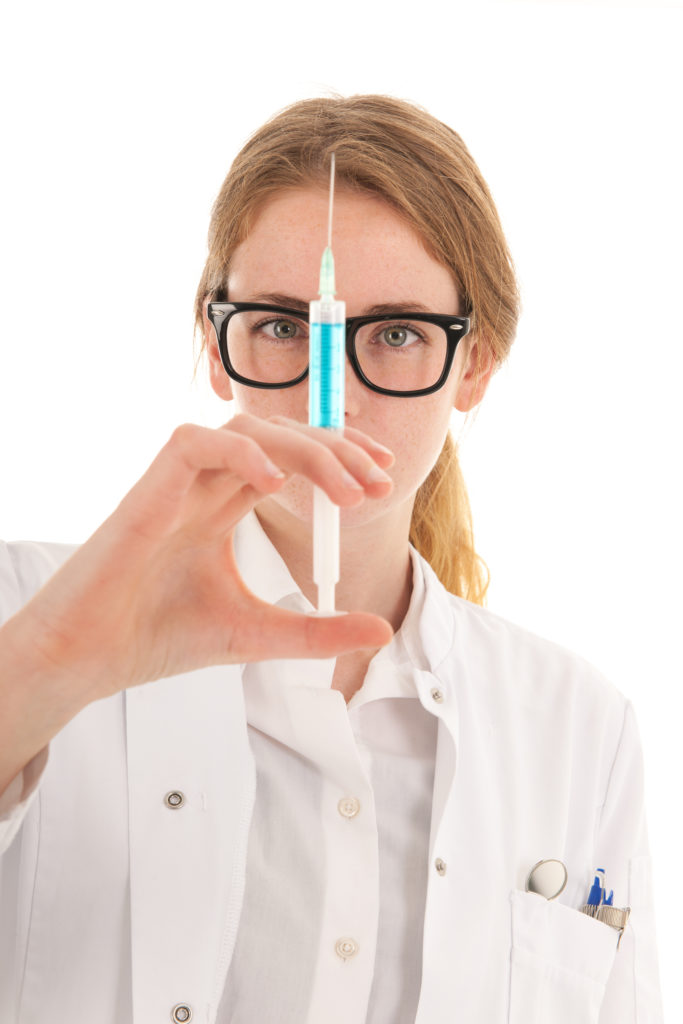 Female dentist with injection needle for dental anesthesia isolated over white background