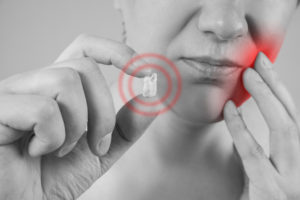 Wisdom tooth extraction, man suffering from a toothache, painful area highlighted in red