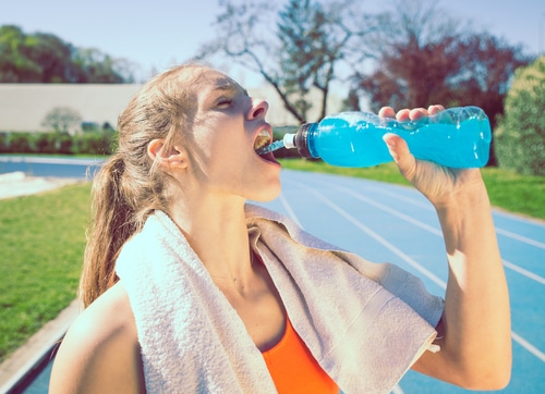 woman drinking power drinking after long run.