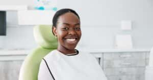 Young woman smiling at dental office, ready for her dental cleaning