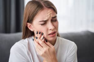 Woman holding her jaw in pain who may need a root canal