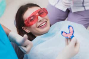 Young woman about to have a fluoride treatment to strengthen her dental enamel and prevent cavities.