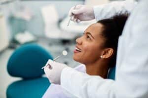 Beautiful young woman having a regular dental exam to protect her gum health and prevent gum disease.